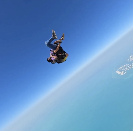 Kaushik Bokka skydiving, upside down in freefall over the coast